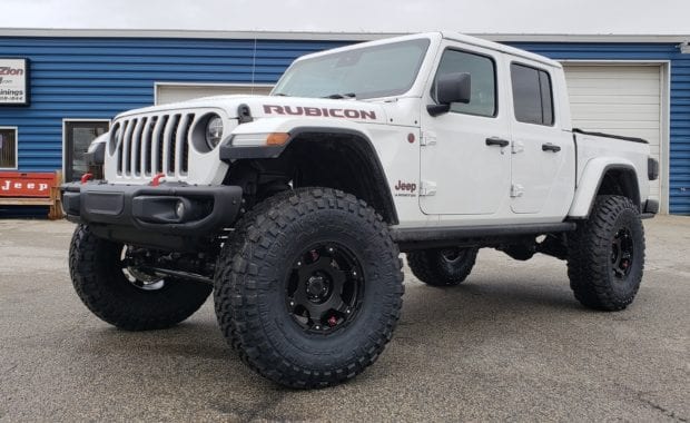 Lifted White Jeep Gladiator on Black wheel and tires front driver side grille view