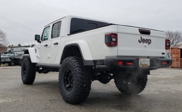 Lifted White Jeep Gladiator on Black wheel and tires rear driver side tailgate view