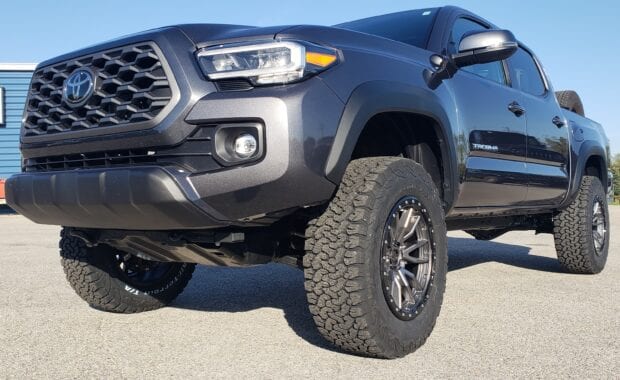 Tacoma with Fuel Rebel D680 Wheel 18x9 6x5.5 (6x139.7) Matte Gunmetal Black 1MM Wheels and LT285/65R18/10 125/122R BFG ALL TERRAIN T/A KO2 Tires close up front driver side grille view