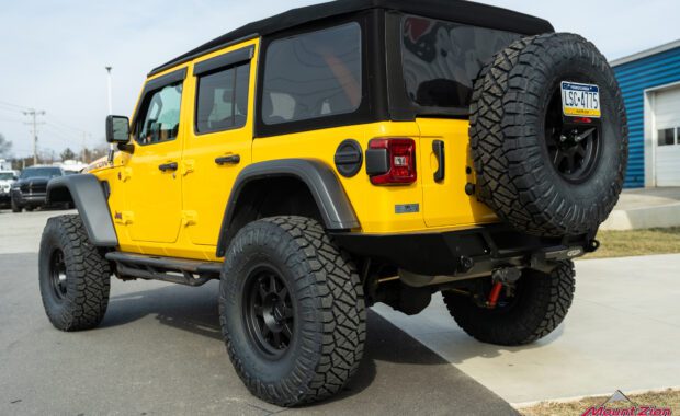 Lifted yellow Rubicon on 38's, driver side rear corner view