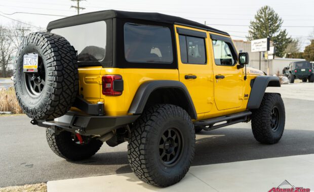Lifted yellow Rubicon on 38's, passenger side rear corner