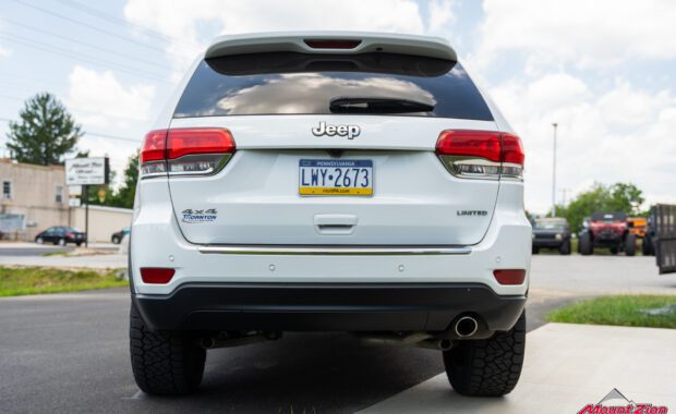 white Jeep grand cherokee with Nitto Tires rear tailgate view