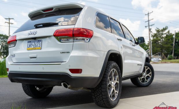 white Jeep grand cherokee with Nitto Tires rear passenger side view