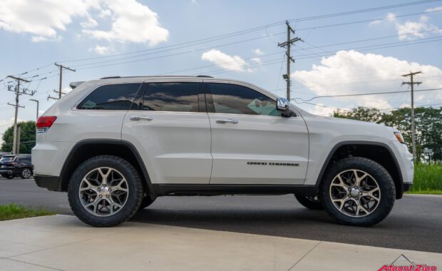 white Jeep grand cherokee with Nitto Tires passenger side view