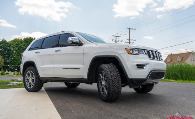 white Jeep grand cherokee with Nitto Tires passenger front side