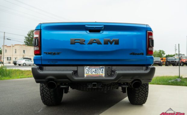 Blue Ram 1500 TRX 4x4 dual exhaust tailgate with jeeps in the background