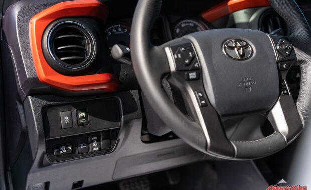 inside of 2020 toyota tacoma steering wheel with red dash accessories