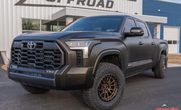 2022 Toyota Tundra 1794 Edition in Satin Black Gold Dust with rough country leveling kit, bronze Fuel Rebel Wheels and Falken Wildpeak Tires front driver side grille view