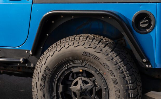intense blue two door 2003 jeep wrangler with metal cloak step and fender on falken wildpeak tires rear driver side wheel well