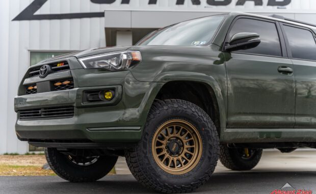 2022 toyota 4runner with bronze kmc wheels and falken wildpeak tires front driver tire with amber fog lights