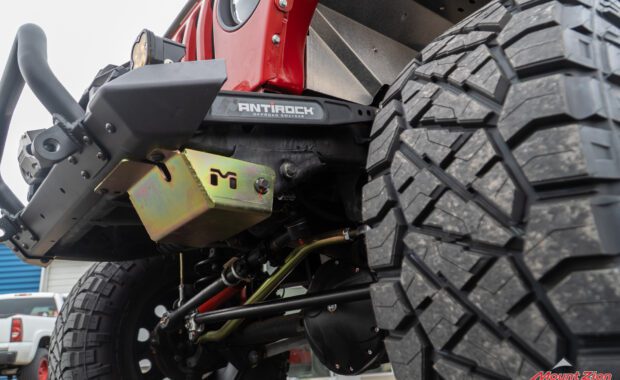 Metal cloak skid plate on red jeep rubicon with antirock offroad sway bar