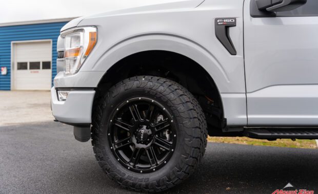 Leveled White Ford F150 STX with Toyo Open Country Tires front driver side