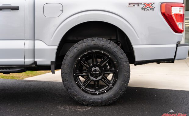 Leveled White Ford F150 STX with Toyo Open Country Tires rear driver side