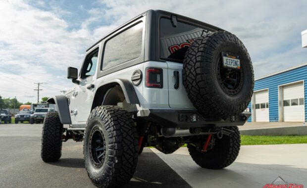 rear driver side of white two door jeep rubicon with rear bumper and rigid bumper lights