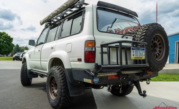1994 toyota land cruiser lifted with black rhino wheels and toyo tires, front bumper, snorkel, roof rack, rock rails, and rear bumper rear driver side view