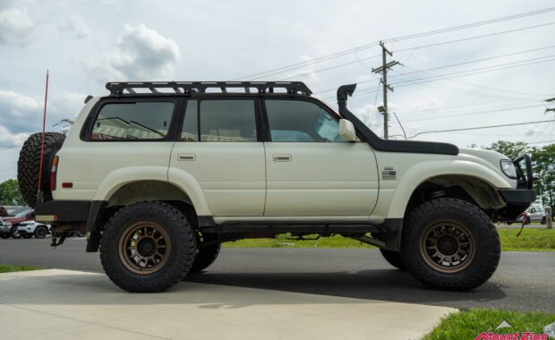 1994 toyota land cruiser lifted with black rhino wheels and toyo tires, front bumper, snorkel, roof rack, rock rails, and rear bumper passenger side view