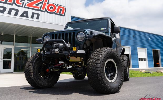 drive side front end view of 2006 jeep wrangler with bumper, winch, offroad lights, lift kits and offroad tires