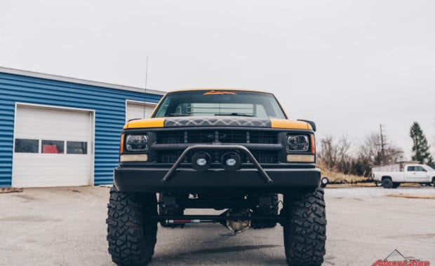 front grille of yellow and black truck with offroad lighting
