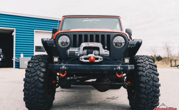 Orange jeep with offroad bumper and warn winch