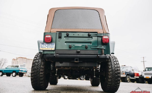 Green two door soft top jeep with Mount Zion offroad branding and winch rear tailgate view