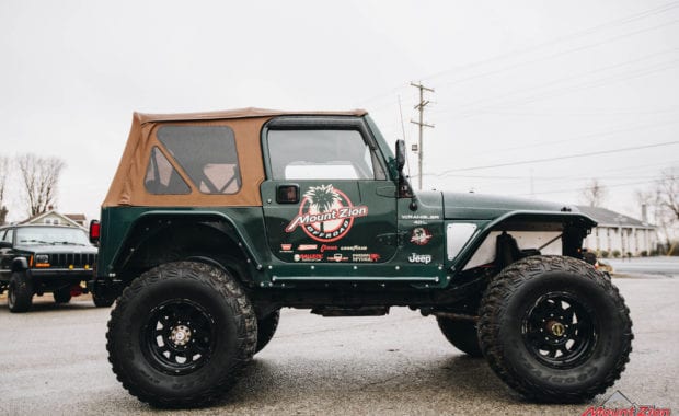 Green two door soft top jeep with Mount Zion offroad branding and winch passenger side view