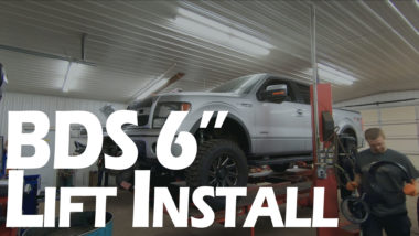 BDS 6" lift install YouTube thumbnail featuring silver F150 on alignment machine