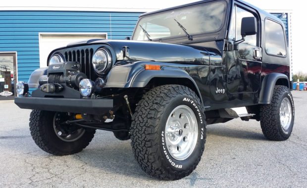 Black Jeep with winch on front bumper upgraded wheels and offroad tires