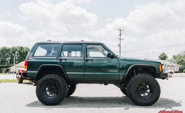 Green Jeep Grand Cherokee lifted with black offroad wheels side passenger view