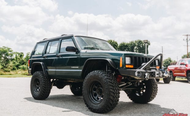 Lifted Green jeep cherokee with offroad front bumper and winch