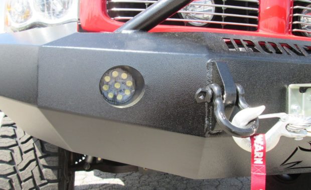 Closeup on iron cross bumper with warn winch and off-road lighting in bumper