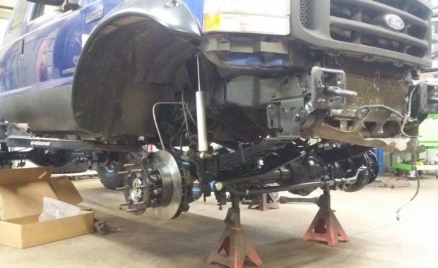 Blue F250 on lift installing new suspension
