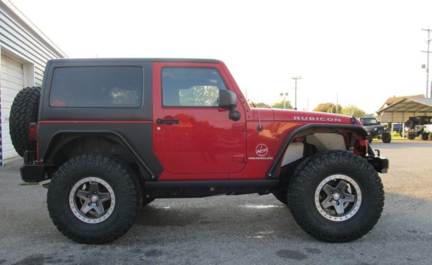 Red Jeep Rubicon with upgraded fender flares wheels and tires
