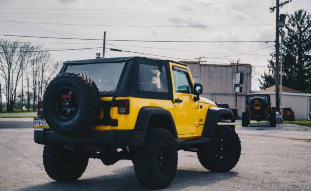 Two door yellow jeep wranlger with soft top with bilstein AEV suspension and fuel wheels rear end