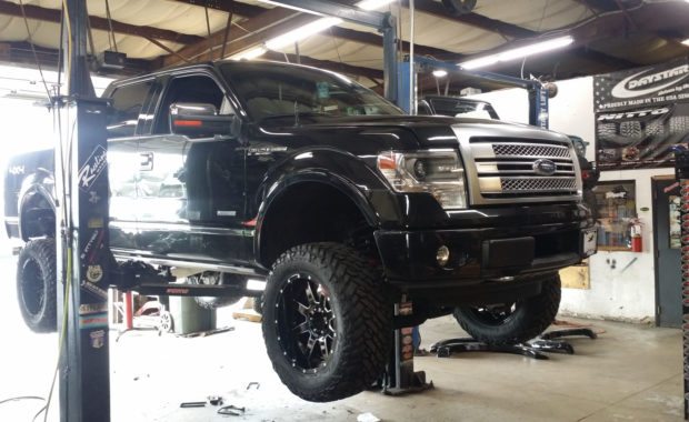 Black F150 on lift with new wheels and tires at mount zion offroad