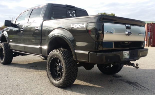 Black 4x4 F150 lifted with fuel wheels driver side rear tailgate