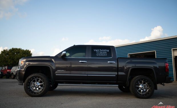 14 grey sierra denali with Rough country lift and chrome wheels driver side view
