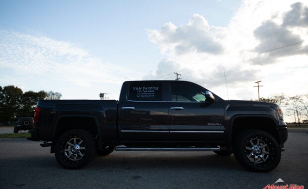 14 grey sierra denali with Rough country lift and chrome wheels passenger side view
