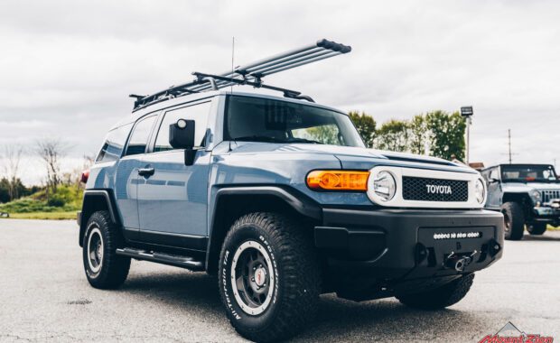 Blue FJ cruiser with roof rack front passenger side grille view