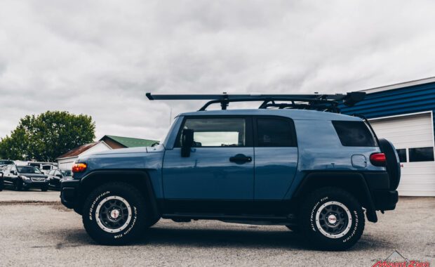 Blue FJ cruiser with roof rack driver side view