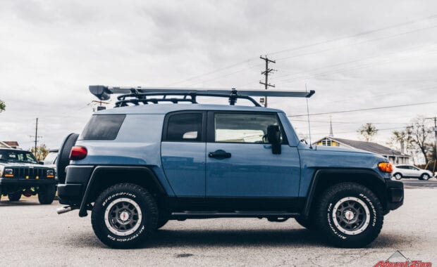 Blue FJ cruiser with roof rack passenger side view