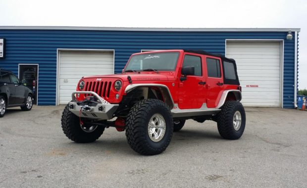 Red Jeep Rubicon lifted with open country wheels, warn winch and bumpers