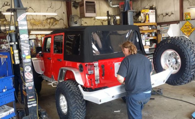Red jeep having rear bumper installed by tech at mount zion offroad