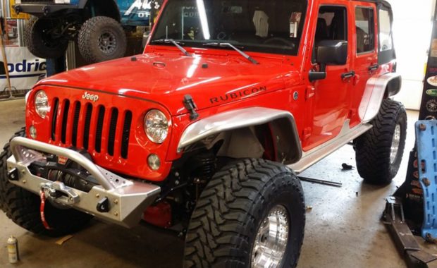 Red Jeep Rubicon with warn winch in shop