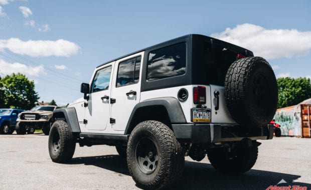 White 2015 Jeep Wrangler on Pro Comp Wheel with Pro Comp Tire rear driver side tailgate view