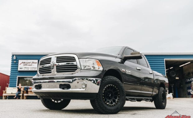 15 Ram 1500 with Bilstein 5100 leveling kit on Method NV 17x8.5 305 Matte Black wheels and LT285/75R17/10 121/118S FAL WILDPEAK A/T3W RBL Tires front driver side grille view