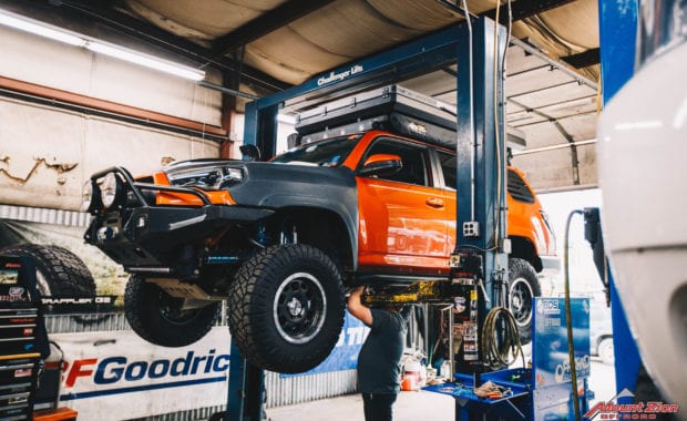 orange 4runner with tent and king suspension on rack at garage