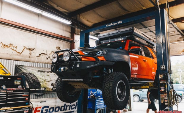 Orange 4runner in lift with tent and offroad bumper