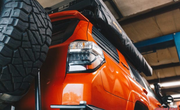 Orange 4runner with awning in bag in shop
