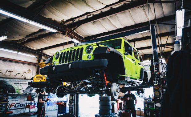 Green 2017 Jeep Wrangler on lift with wheels off