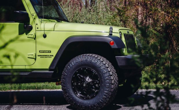Jeep wrangler sport unlimited with fuel wheels on backroad